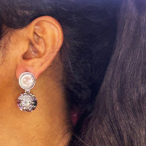 Silver earrings with an ornate design, featuring a round white stone and intricate detailing for a vintage-inspired look. From Trenzify Store.