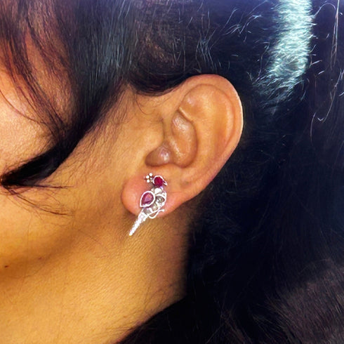 Silver peacock-shaped earrings adorned with ruby and clear gemstones, showcasing an elegant bird design with vivid red accents. From Trenzify Store.