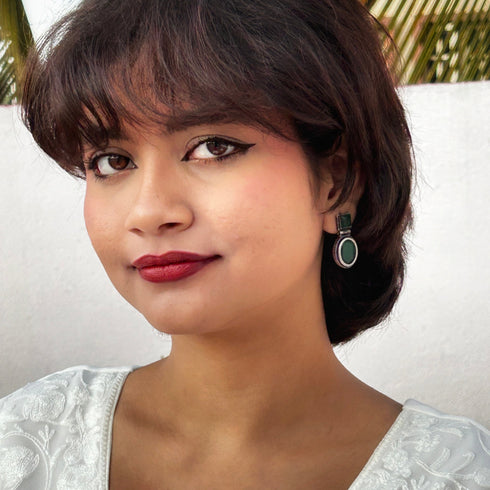 Statement earrings featuring rich green gemstones in a dual-shape design, square top and oval drop, encased in antique silver finish. Trenzify Store