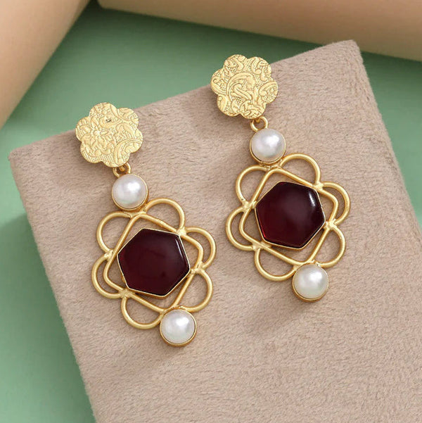 Gold-plated drop earrings featuring maroon stone centers and white pearl accents, with a floral design at the top, offering a sophisticated look for any occasion from Trenzify Store.