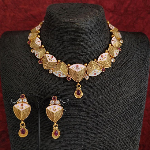 Rajwadi antique gold-plated Meenakari necklace set with ruby stones and matching earrings on red background.