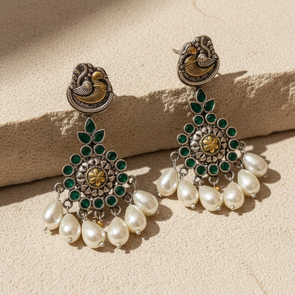 Oxidized peacock pearl drop earrings with green stones, floral center detailing and antique silver finish in ethnic statement design