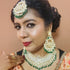 Bride wearing a traditional Kundan bridal necklace set with green bead drops, gold-plated finish, and matching chandbali earrings and maang tikka, perfect for weddings and festive occasions from Trenzify Store.