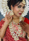 Indian bride wearing elegant Kundan bridal jewelry set with long necklace, matching earrings , and maang tikka embellished with pearls and stones - Trenzify Store.