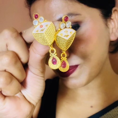 Rajwadi antique gold-plated Meenakari necklace set with ruby stones and matching earrings on red background.