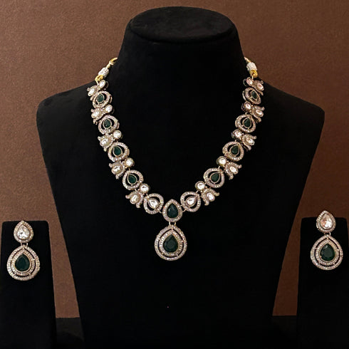 Elegant green red stone necklace set with matching drop earrings, featuring teardrop design, white CZ embellishments, and gold-plated finish – perfect for weddings and festive occasions.