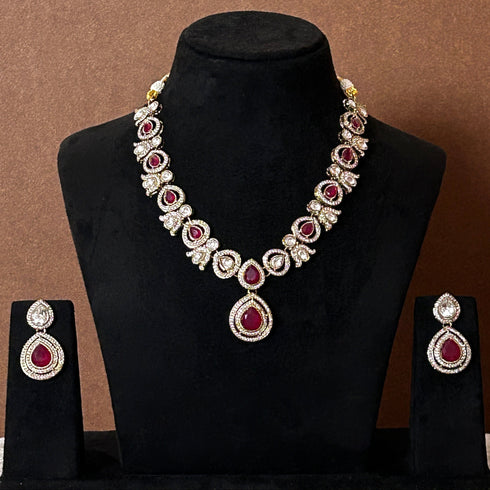 Elegant ruby red stone necklace set with matching drop earrings, featuring teardrop design, white CZ embellishments, and gold-plated finish – perfect for weddings and festive occasions.