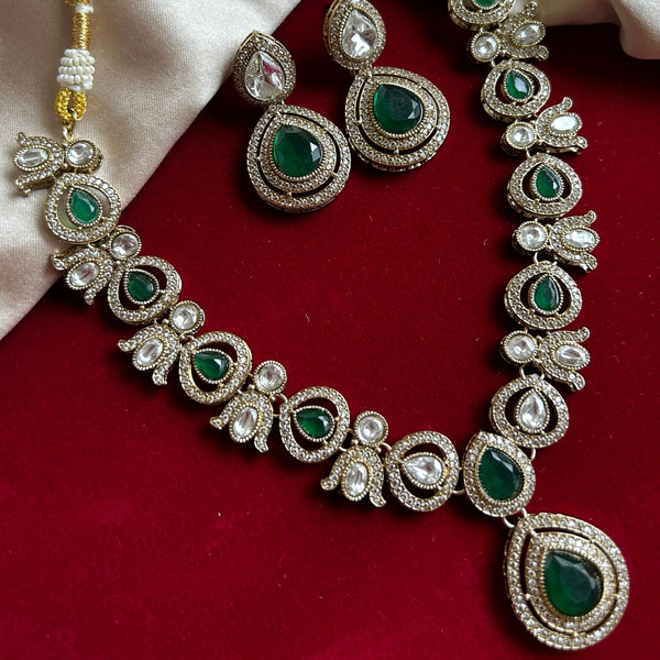 Elegant green red stone necklace set with matching drop earrings, featuring teardrop design, white CZ embellishments, and gold-plated finish – perfect for weddings and festive occasions.