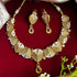 Rajwadi antique gold-plated Meenakari necklace set with ruby stones and matching earrings on red background.