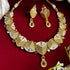 Rajwadi antique gold-plated Meenakari necklace set with ruby stones and matching earrings on red background.
