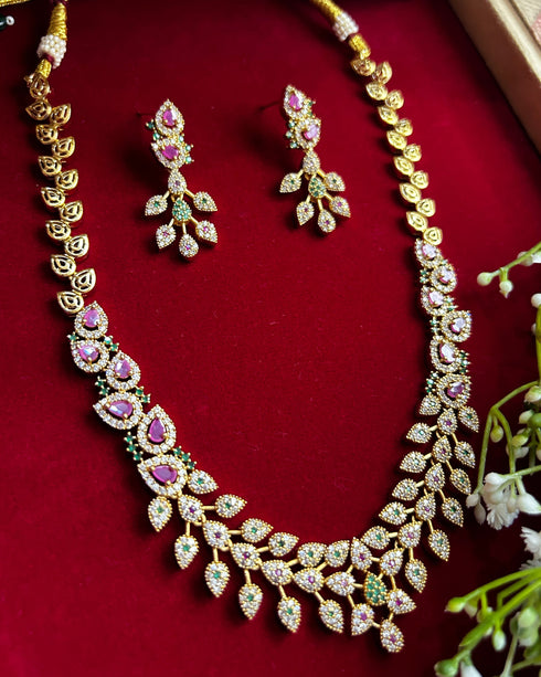 American Diamond CZ necklace set with pink stones, green accents and gold plated finish – elegant floral design jewelry with matching earrings.