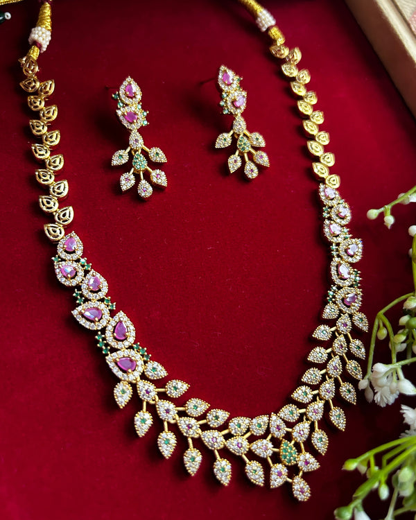 American Diamond CZ necklace set with pink stones, green accents and gold plated finish – elegant floral design jewelry with matching earrings.