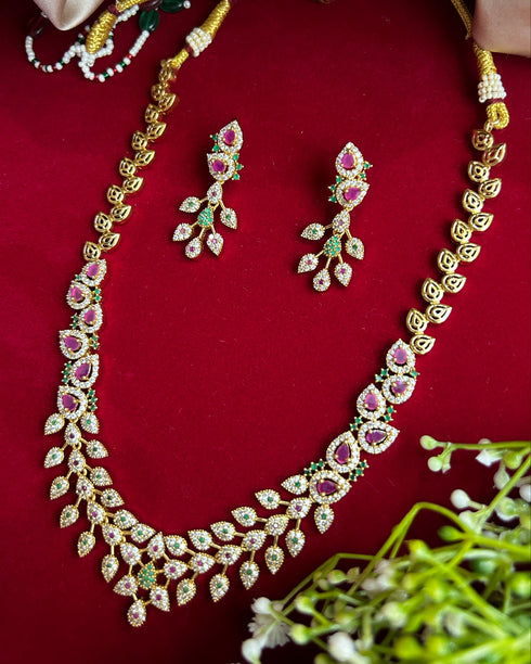 American Diamond CZ necklace set with pink stones, green accents and gold plated finish – elegant floral design jewelry with matching earrings.