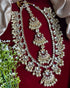 Traditional Kundan bridal jewelry set with long necklace, matching earrings , and maang tikka embellished with pearls and stones - Trenzify Store.