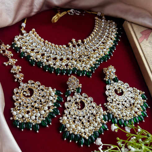Traditional Kundan bridal necklace set with green bead detailing, gold plating, and matching chandbali earrings and Maang Tikka from Trenzify Store.