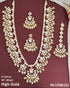 Indian bride wearing elegant Kundan bridal jewelry set with long necklace, matching earrings , and maang tikka embellished with pearls and stones - Trenzify Store.