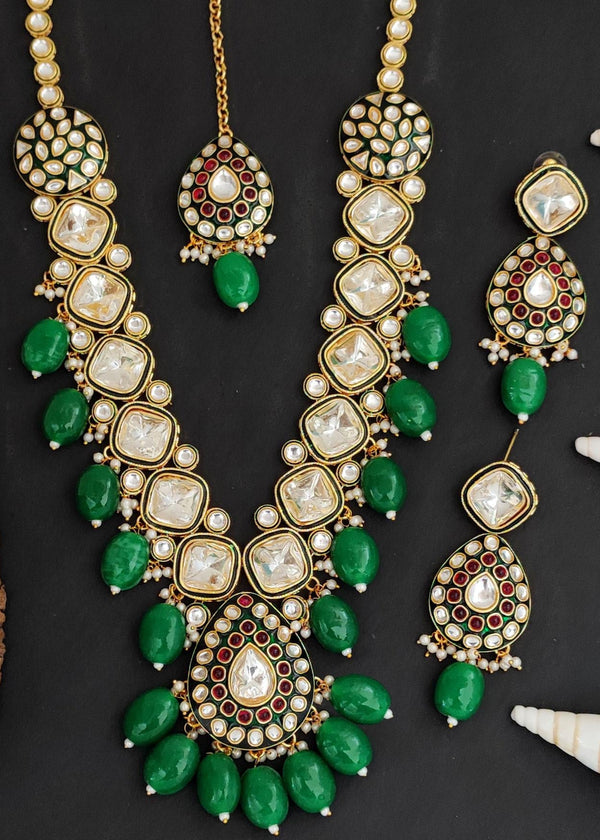 Gold plated Kundan necklace set with green stones, red enamel accents, pearls and matching earrings and maang tikka – traditional bridal jewelry from Trenzify Store.